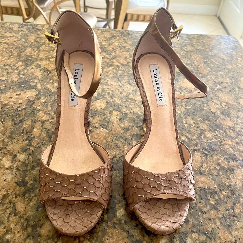 taupe pair high heeled sandals with shell designs in front with gold accent.